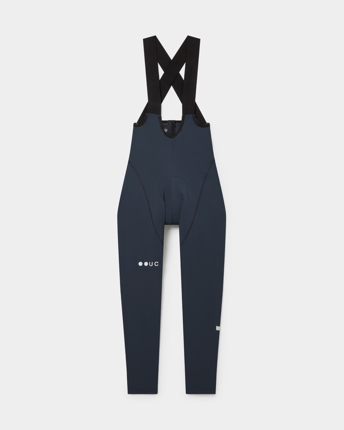 Flatlay of the Women's Mono Bib Tight in Eclipse Navy: crossed shoulder straps, integrated chamois and UC logo on the thigh.