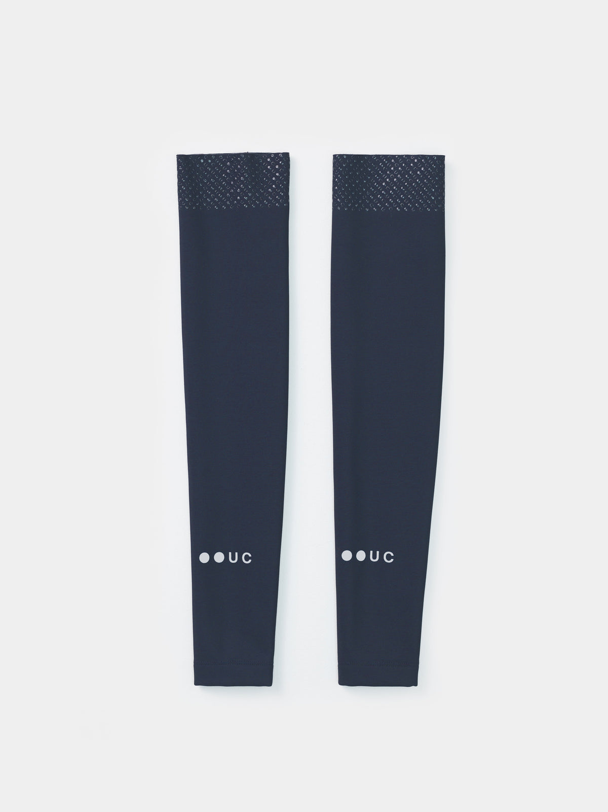 Flatlay of the Eclipse Navy Arm Warmers showing silicone UC-motif gripper band at the bicep and UC forearm wordmark.