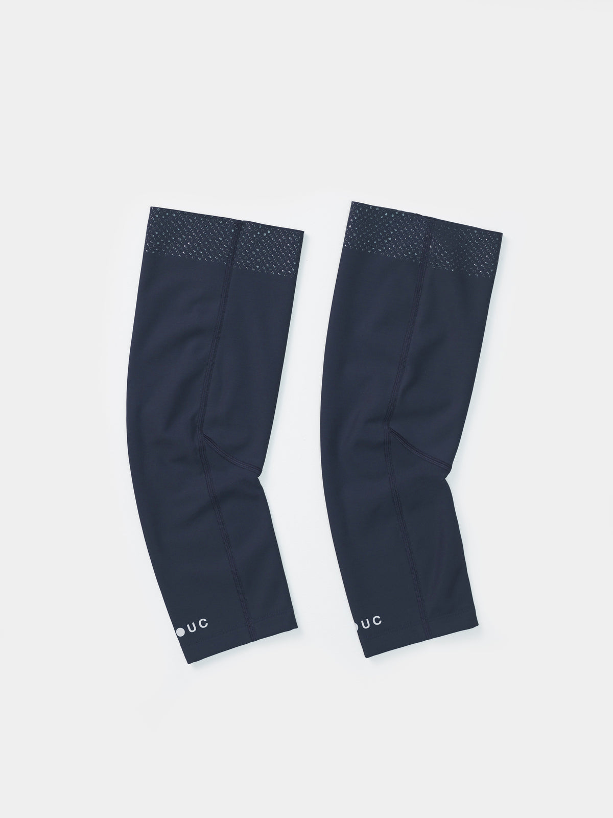 Flatlay of the Universal Colours Knee Warmers in Eclipse Navy, pair laid side by side showing silicone grip dot band at the thigh.