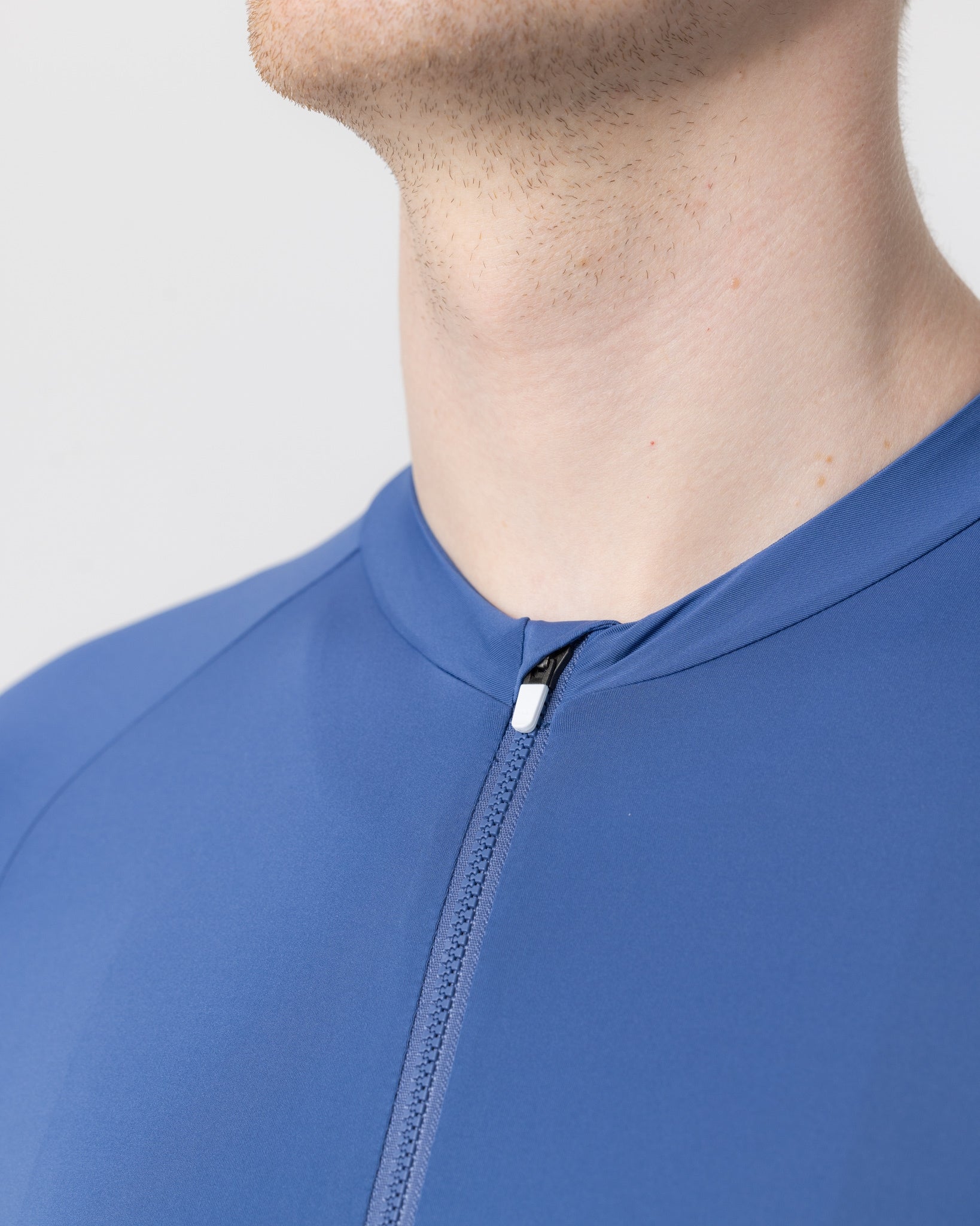 Close-up of the French Blue Mono Short Sleeve Jersey collar, full-length zip and white zip-garage tab at the throat.