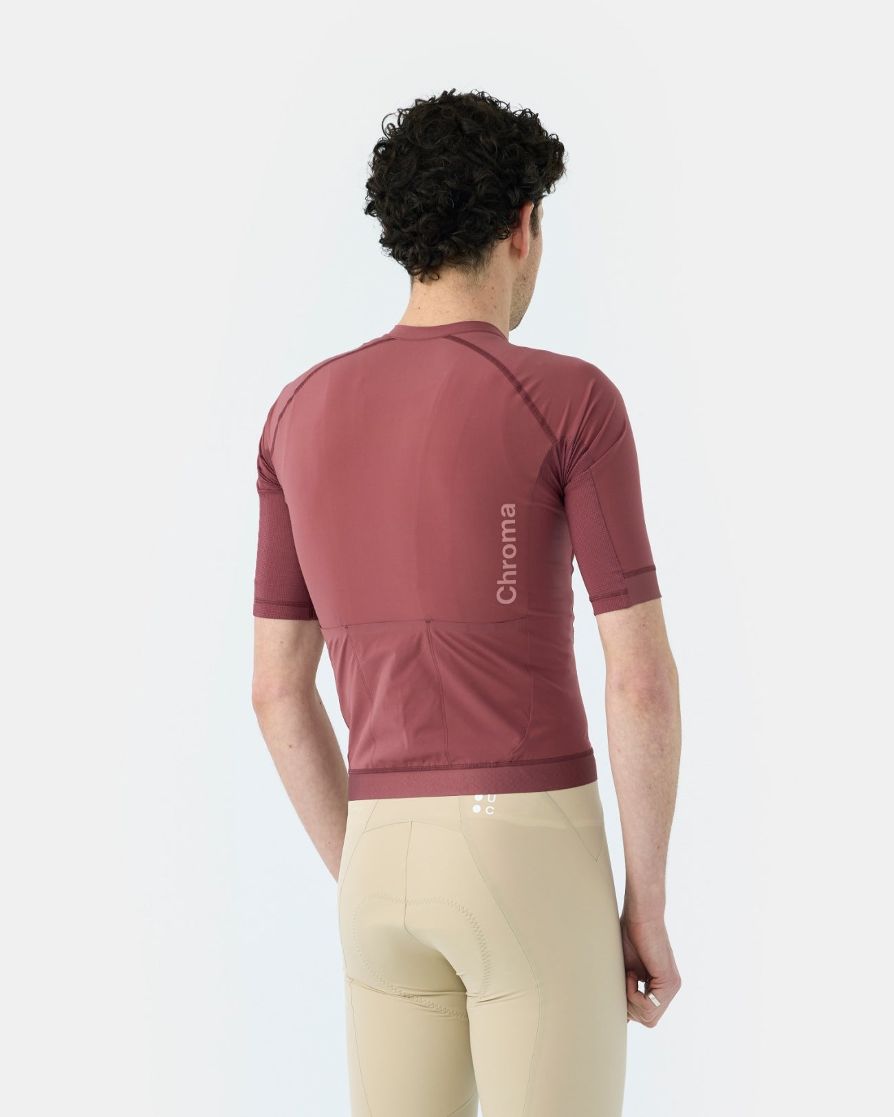 Back view: Men's Chroma Short Sleeve Jersey in Jaipur Red showing vertical tonal Chroma wordmark and dropped tail hem.