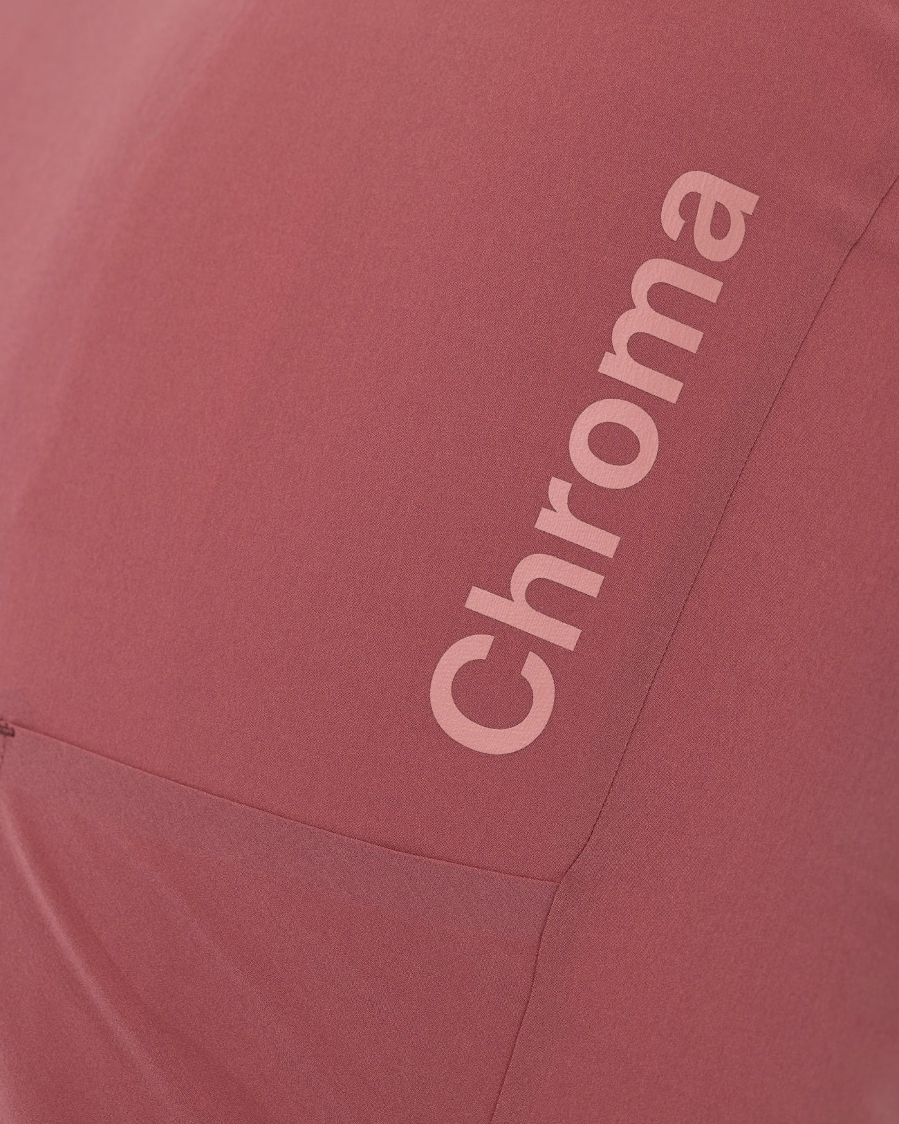 Detail of the tonal pink Chroma wordmark printed vertically high on the back of the Men's Jaipur Red jersey.