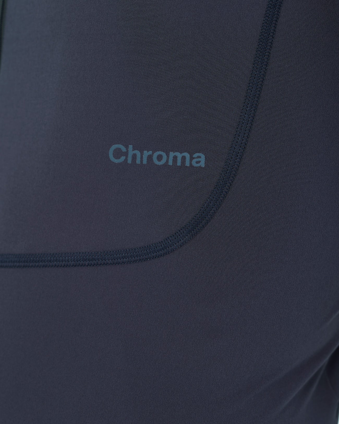 Close-up of the tonal Chroma logo on the hem panel of the Men's Chroma Short Sleeve Jersey in Midnight Blue.