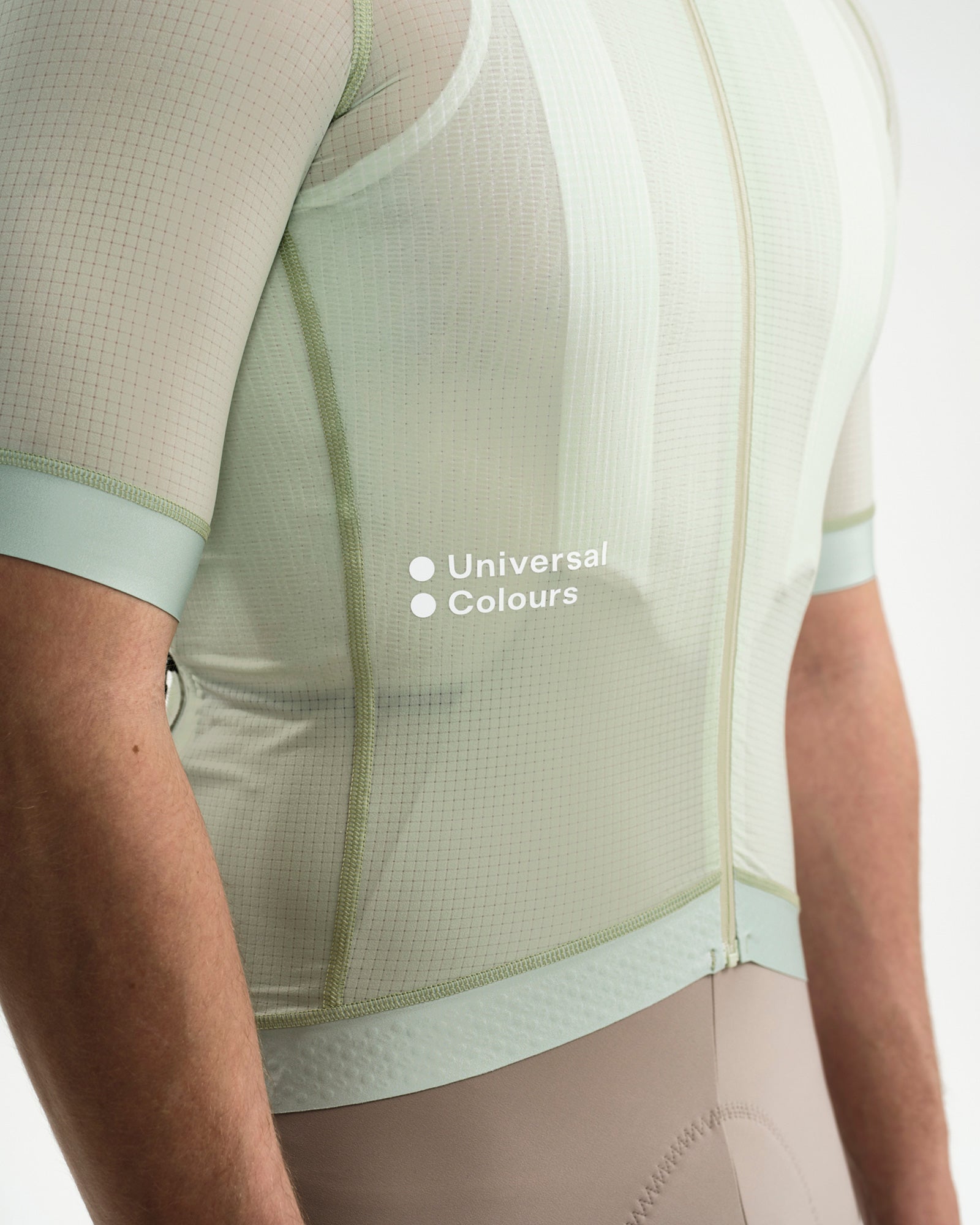 Side torso close-up: sheer ripstop mesh and white 'Universal Colours' chest wordmark on the Bower Green Jersey.