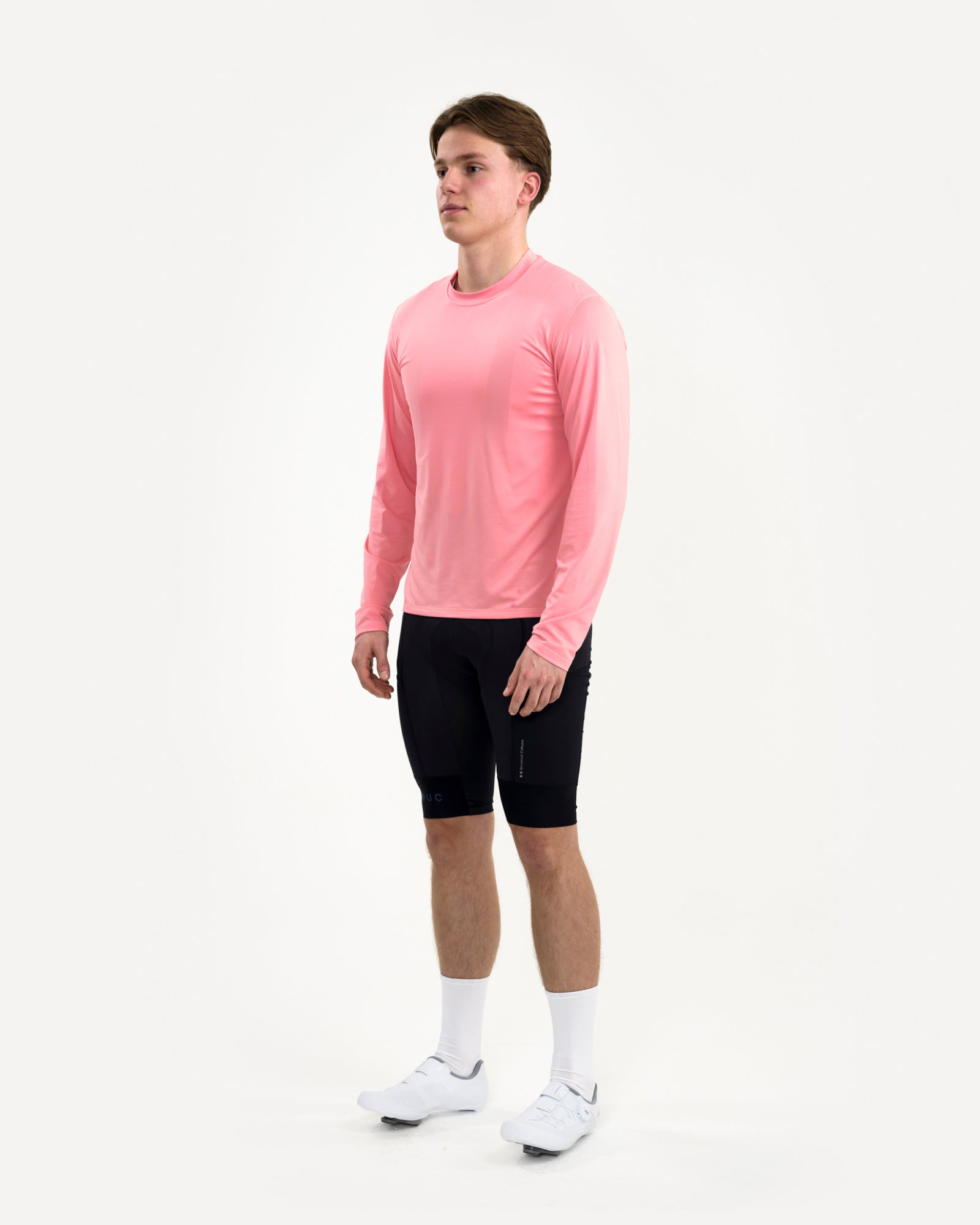Men's front-three-quarter view of the Long Sleeve Tech Tee in Washed Pink, paired with black UC cycling bib shorts.