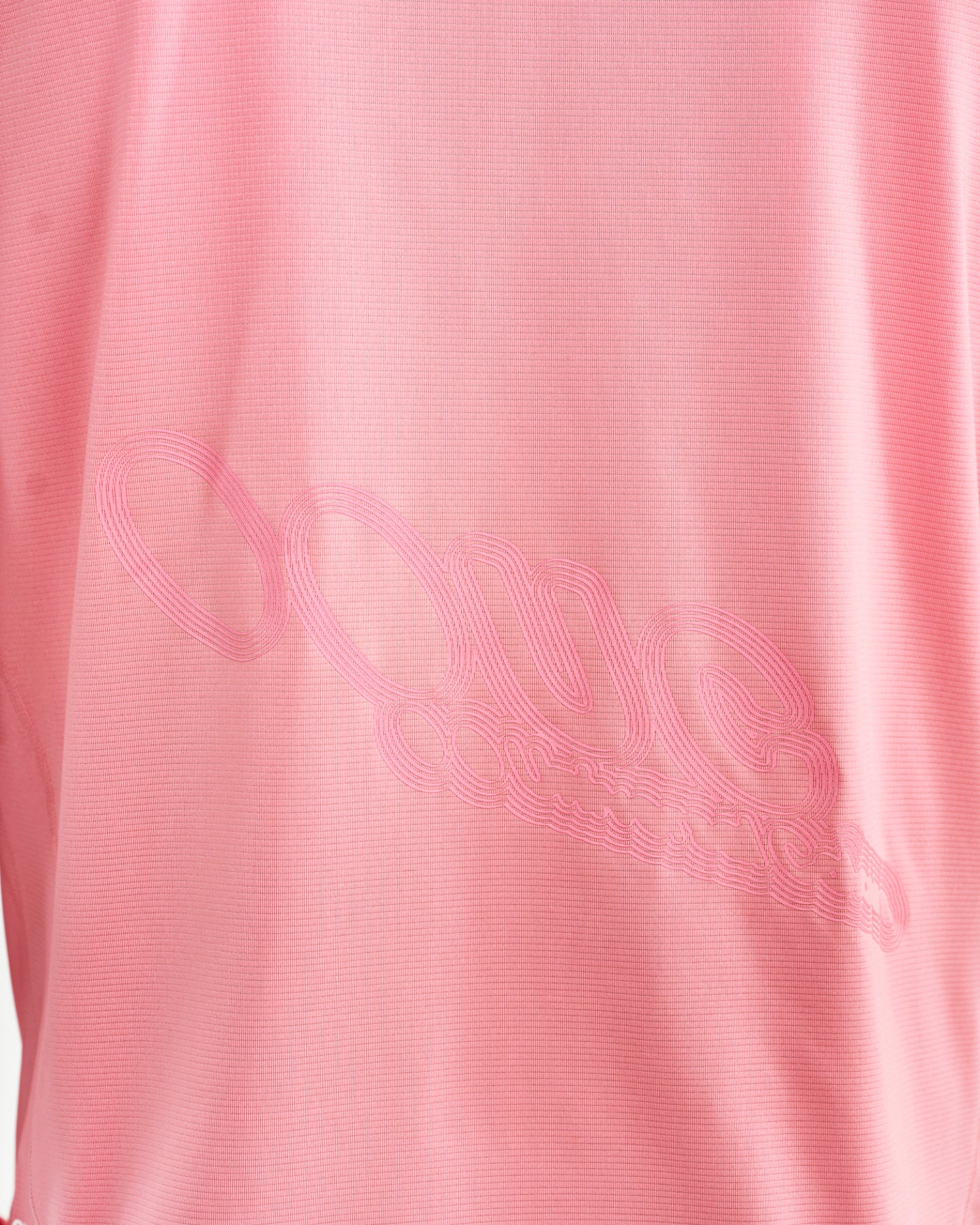 Back graphic close-up on the Long Sleeve Tech Tee in Washed Pink: tonal Universal Colours script across waffle-knit fabric.