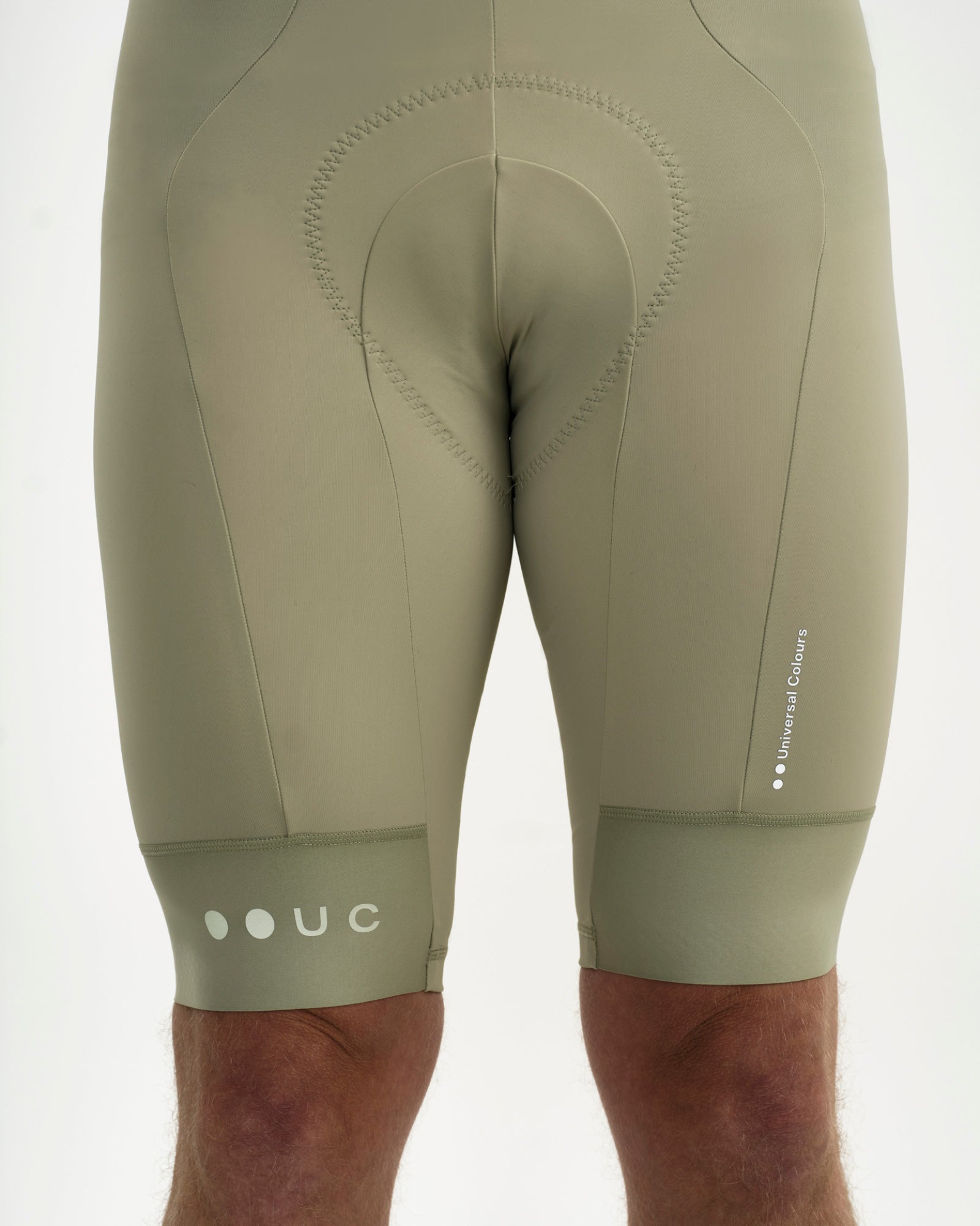Front close-up of the Men's Mono Bib Shorts 2.0 in Green Tea: contoured chamois, UC hem mark and Universal Colours wordmark.