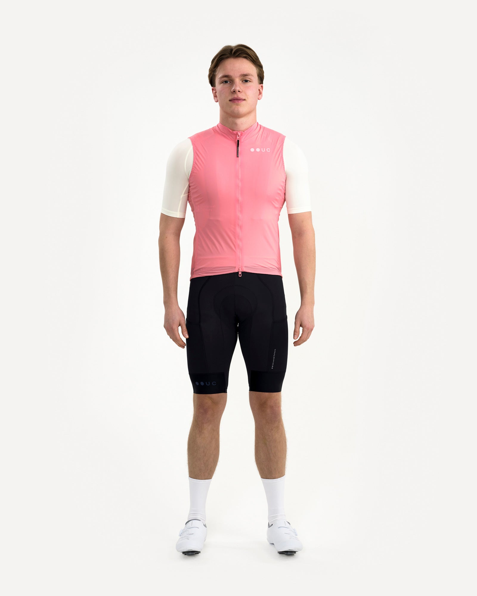 Model wearing the Men's Mono Gilet 2.0 in Washed Pink, front view, styled with cream jersey and black bib shorts.