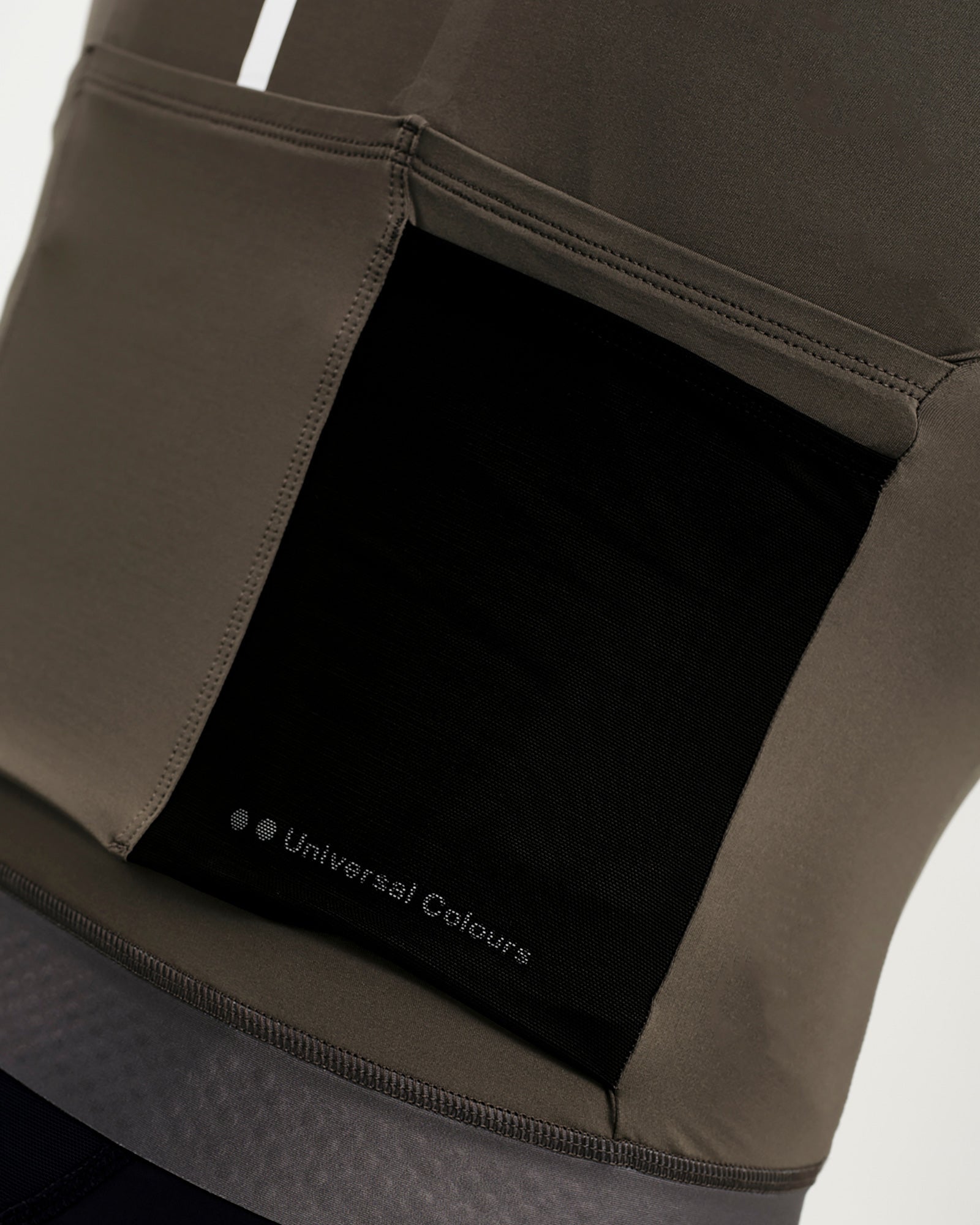 Side panel detail: black mesh ventilation insert with tonal Universal Colours wordmark on the Men's Mono Jersey.