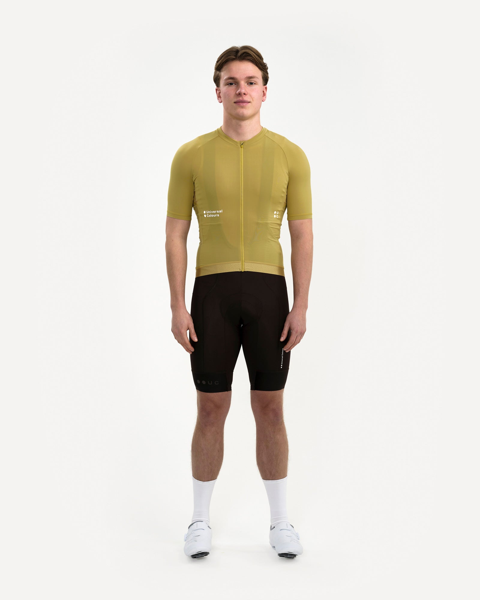 Front view: model in the Men's Mono Short Sleeve Jersey in Acidic Yellow with black UC bib shorts, socks and white shoes.