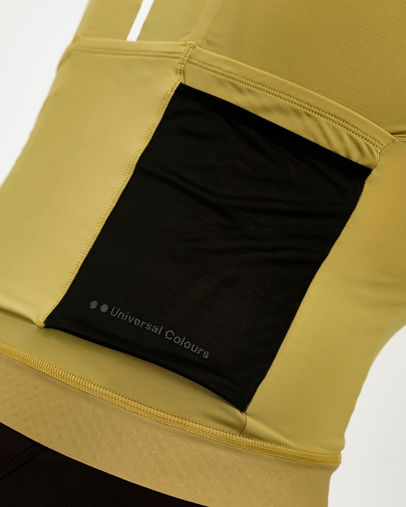 Rear pocket detail: black mesh stretch panel with reflective Universal Colours wordmark on the Acidic Yellow jersey.