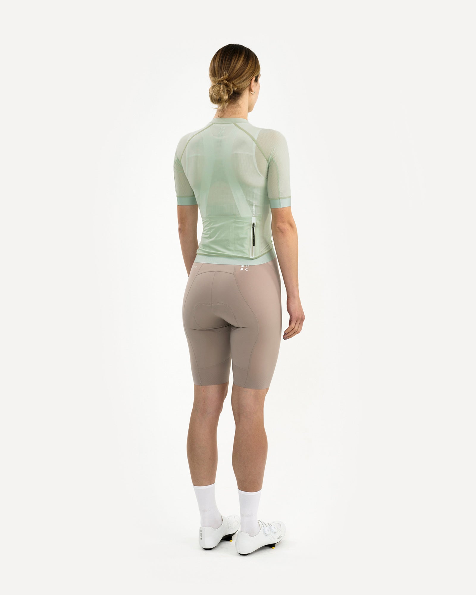 Women's Chroma Light Jersey in Bower Green, back three-quarter view showing translucent mesh fabric and dropped tail hem.