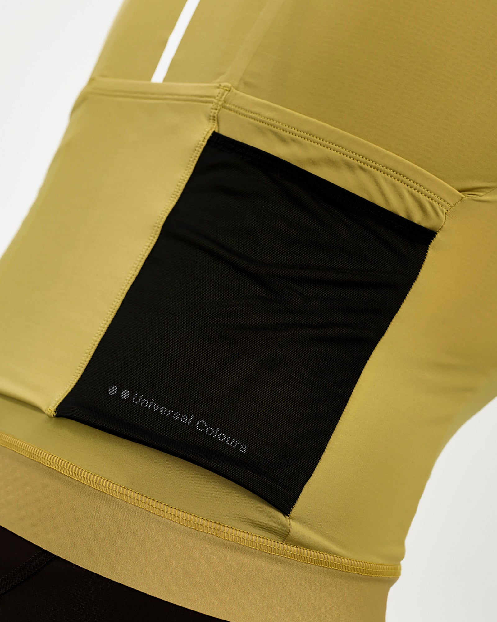 Rear pocket detail: black mesh stretch pocket with tonal Universal Colours wordmark on the Acidic Yellow Mono jersey.