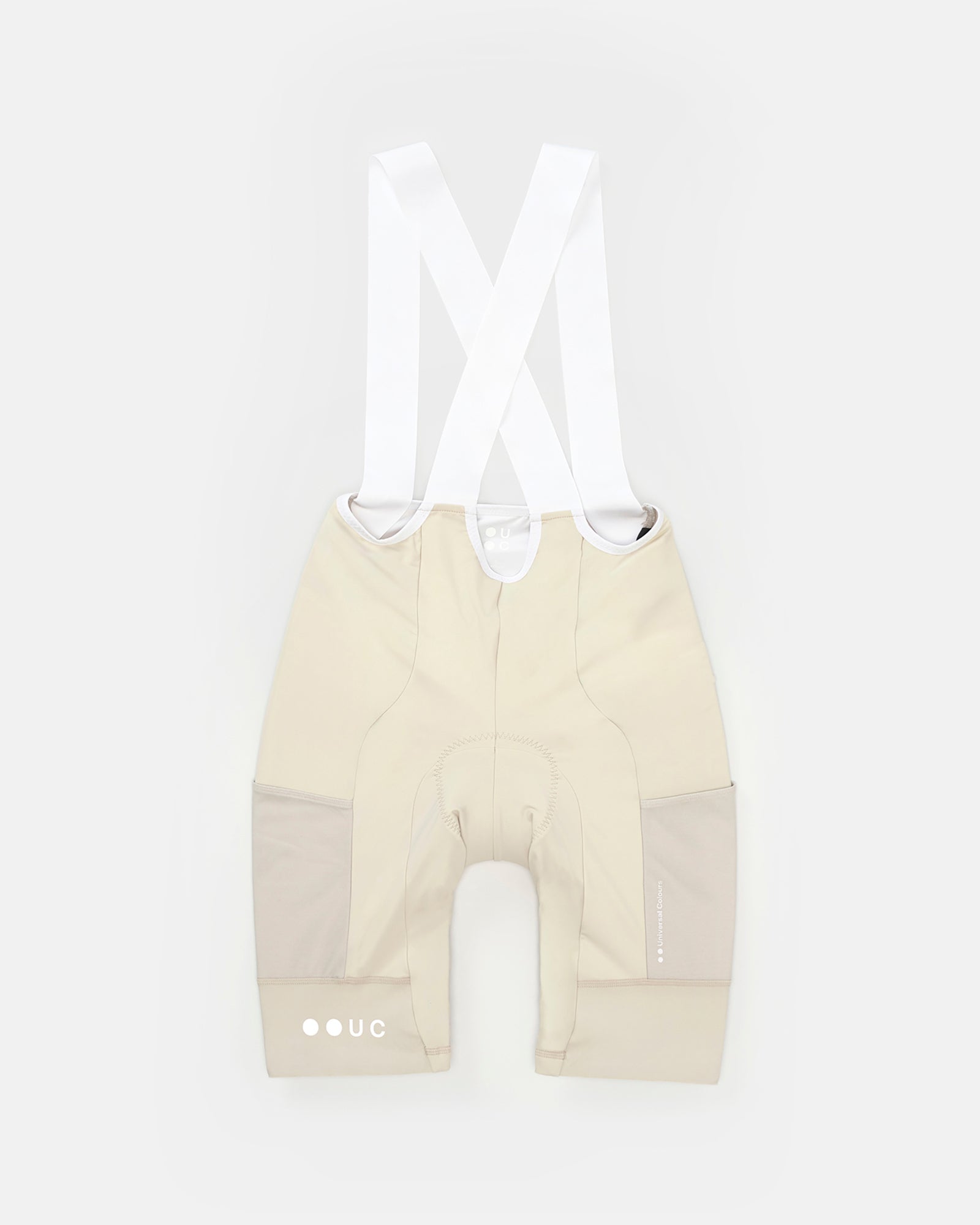 Women's Mono Cargo Bib Short in Off White, flatlay back view, white crossover straps and tonal mesh side cargo panels.