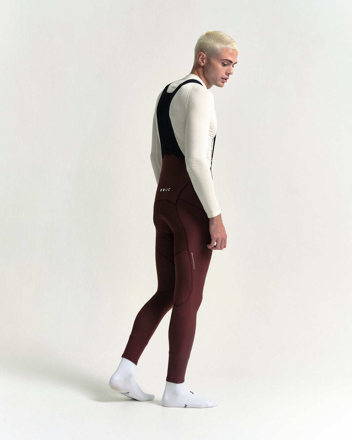 Model in the Men's Mono Bib Tight in Deep Red, full-length view.