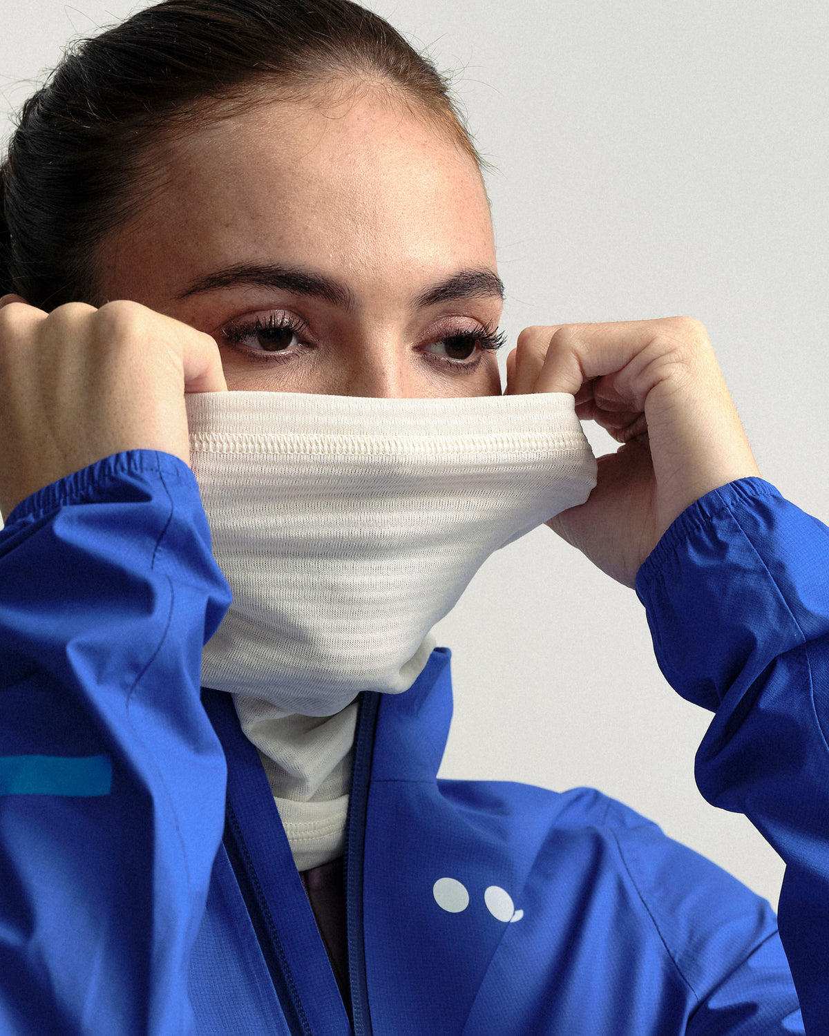Model wearing the Polartec Neck Warmer in Off White.