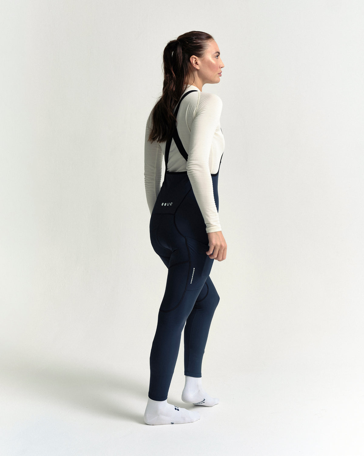 Model wearing the Women's Mono Cargo Bib Tight in Eclipse Navy.