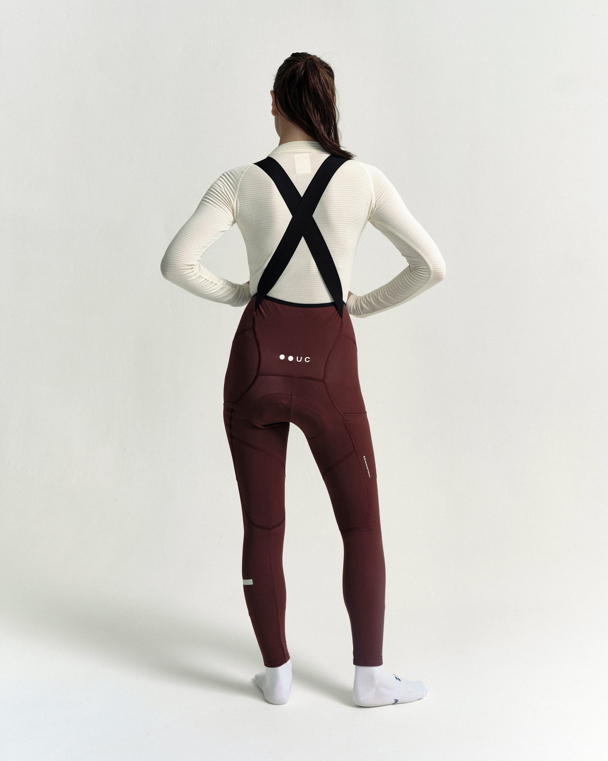 Model wearing the Women's Mono Cargo Bib Tight in Deep Red.