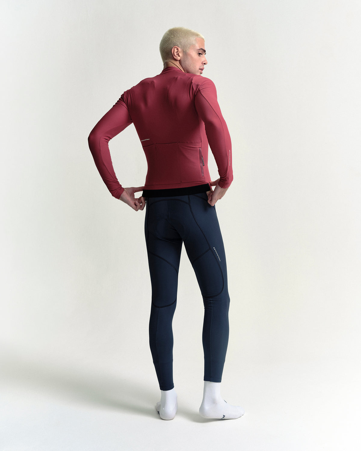 Model in the Men's Mono Long Sleeve Jersey in Apple Red, full-length back view.