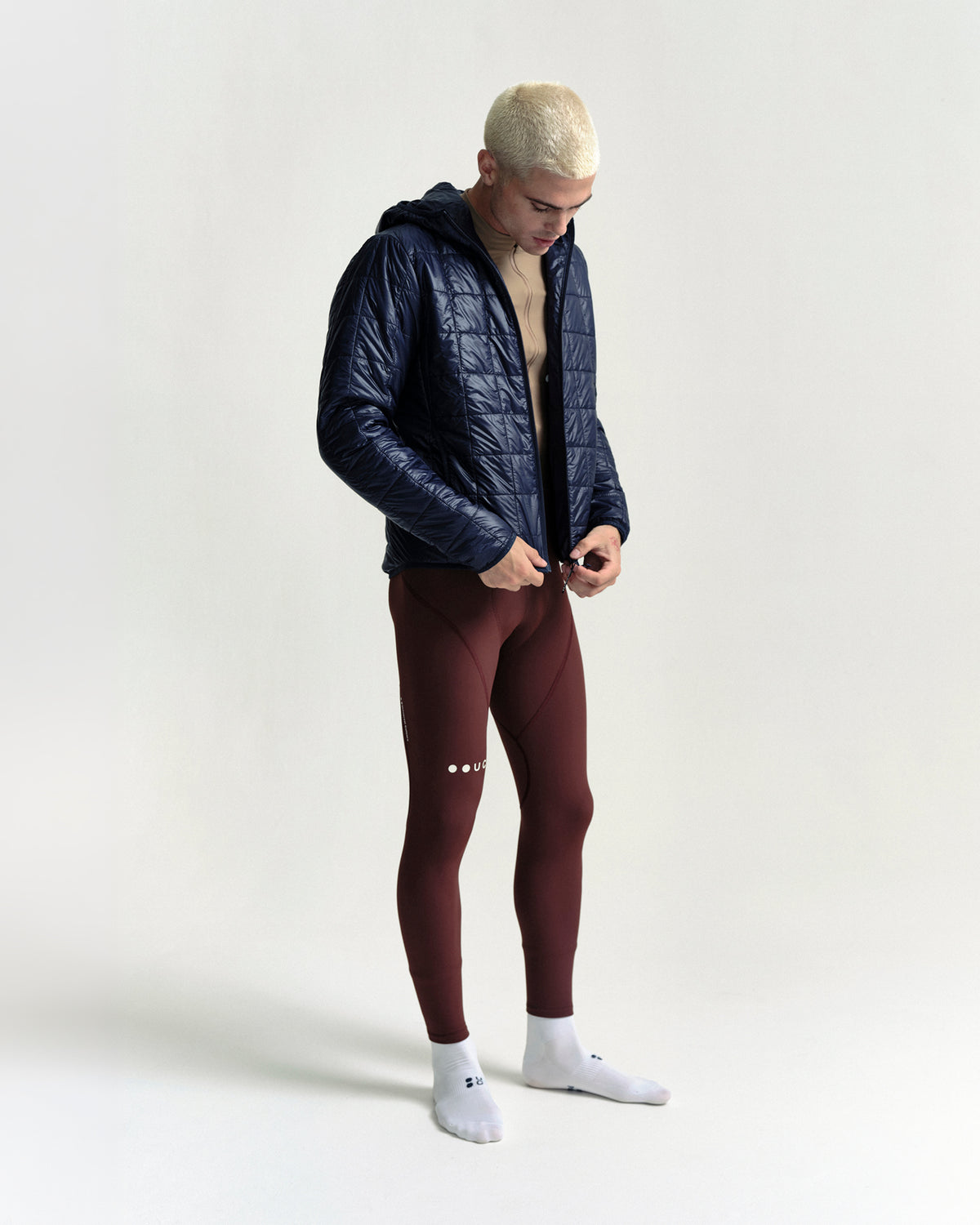 Model wearing the Unisex Insulated Packable Jacket in Ink Blue.