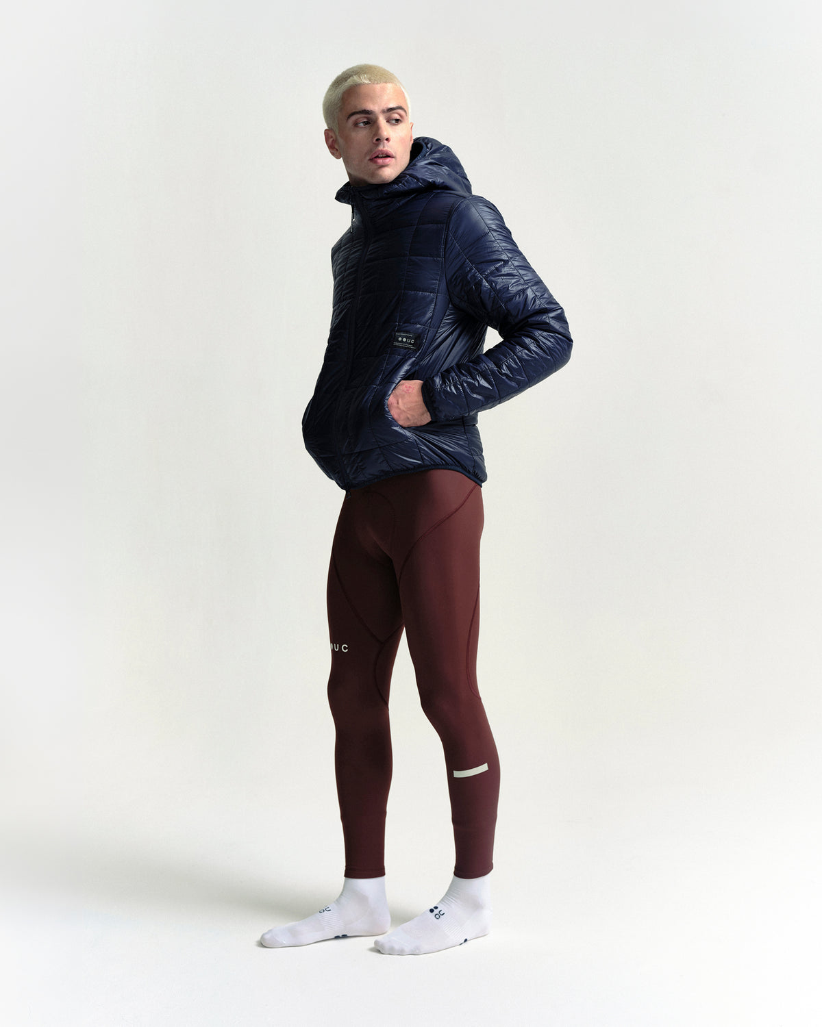 Model wearing the Unisex Insulated Packable Jacket in Ink Blue.