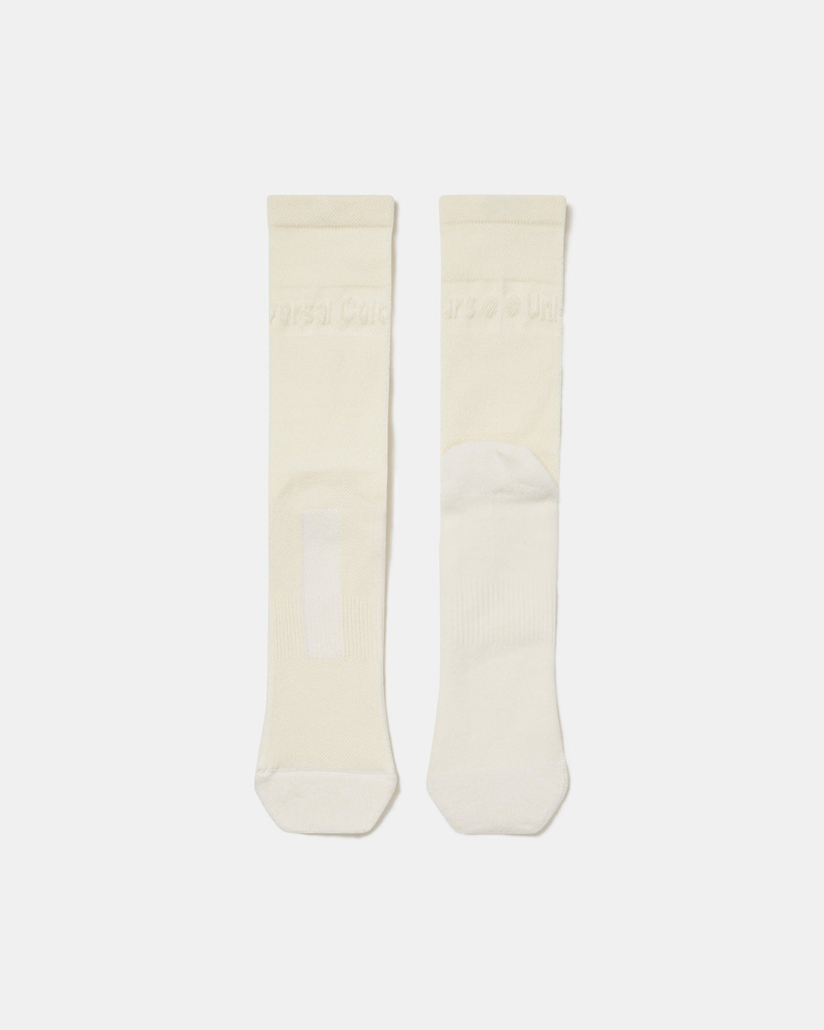 Flatlay of the Merino Winter Socks in Off White, showing the tonal Universal Colours wordmark at the cuff.