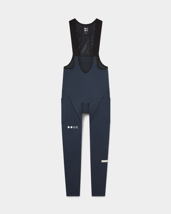Flatlay of the Men's Mono Cargo Bib Tight in Eclipse Navy: mesh upper bib, side thigh cargo pockets and UC leg logo.
