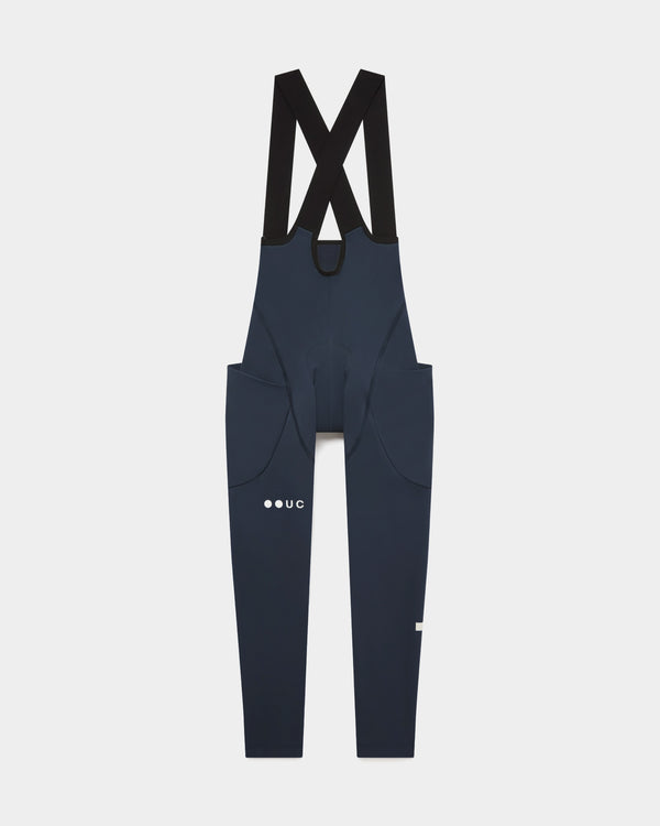 Women's Mono Cargo Bib Tight in Eclipse Navy, flatlay front view: crossover straps and twin stretch thigh cargo pockets.