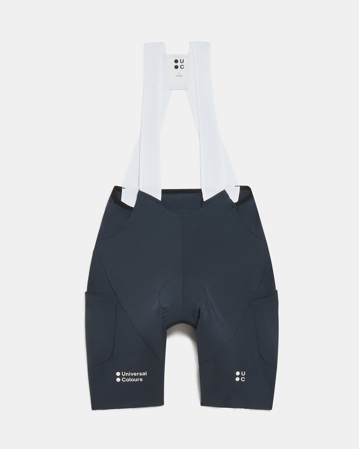 Flatlay of the Women's Chroma Cargo Bib Shorts in Navy Blue: ribbed bib straps, a pocket on each thigh and Universal Colours leg logos.