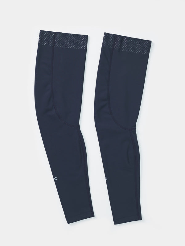 Flatlay of the UC Leg Warmers in Eclipse Navy: silicone gripper dots at the top hem and UC wordmark near the cuff.