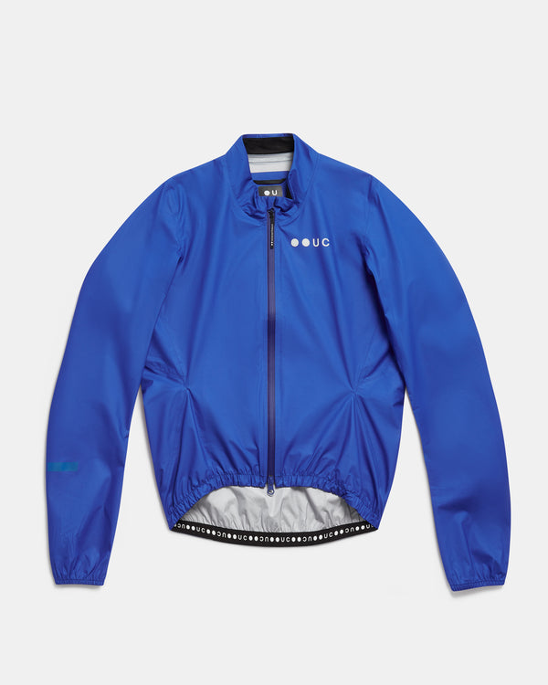 Flatlay of the Men's Mono Rain Jacket in Vivid Blue: ripstop shell, full-length zip and UC chest logo.