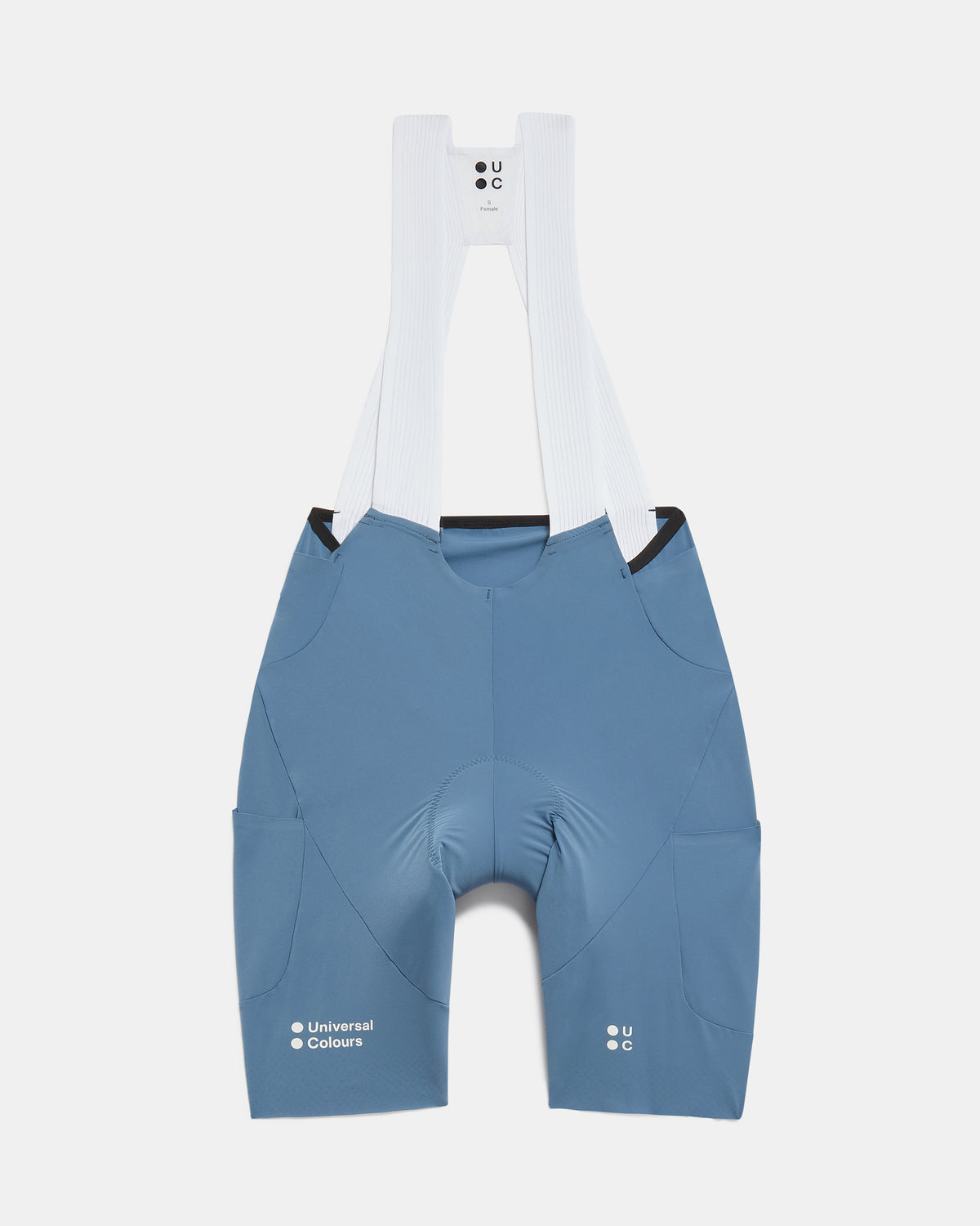 Flatlay of the Women's Chroma Cargo Bib Shorts in Slate Blue: ribbed bib straps, a pocket on each thigh and Universal Colours leg logos.