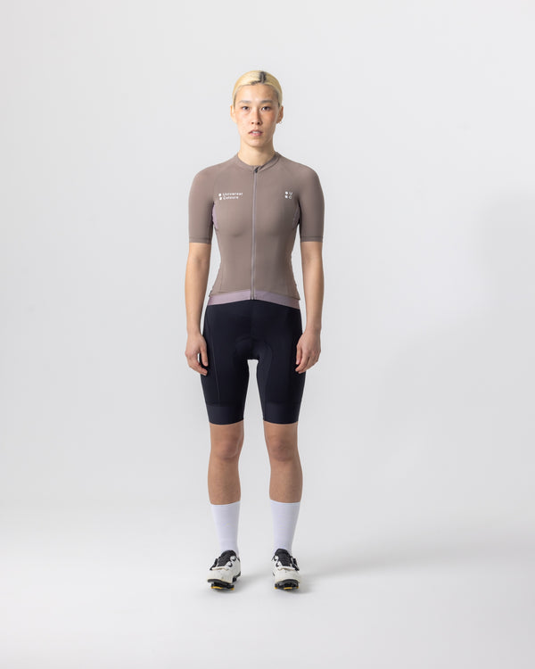 Model wearing the Women's Mono Short Sleeve Jersey in Portobello Grey, paired with black bib shorts and white socks.