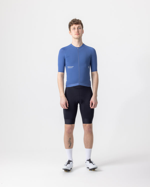 Model wearing the Men's Mono Short Sleeve Jersey in French Blue, front view, paired with black cycling bib shorts.