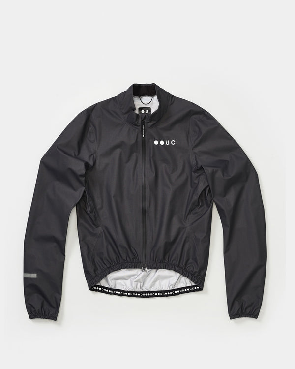 Flatlay of the Men's Mono Rain Jacket in Black: mock collar, full-length zip and white UC chest logo.