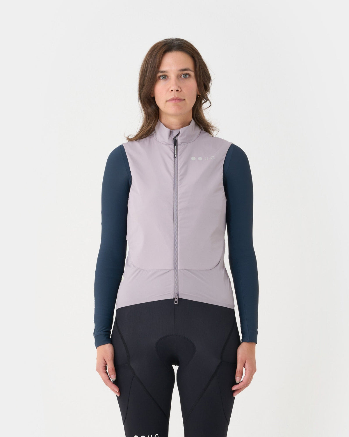 Model in the Chroma Insulated Gilet in Lilac Mist over a navy long-sleeve base layer and black bib tights.