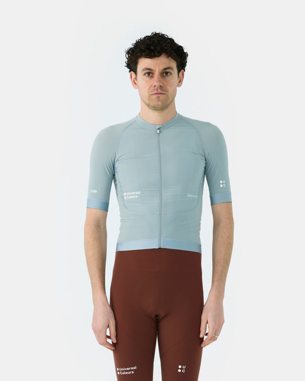 Model wearing the Men's Chroma Short Sleeve Jersey in Sky Blue, front view, paired with Heavy Bark Brown cycling bib shorts.