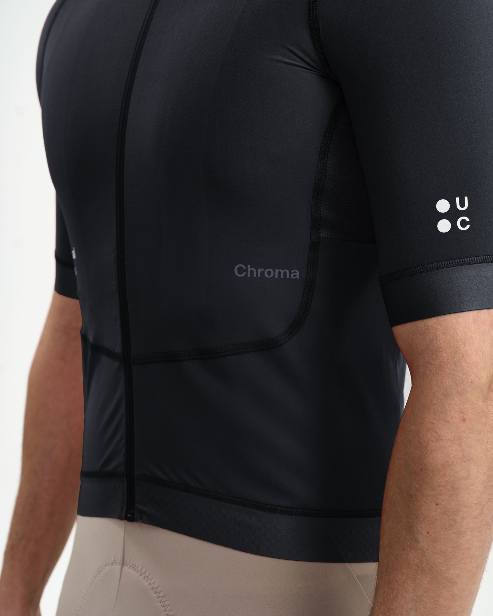 Side detail: tonal Chroma wordmark, mesh side panel and white UC sleeve logo on the Chroma Jersey in Black.
