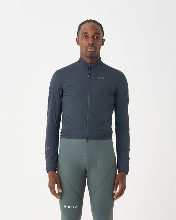 Model wearing the Men's Mono Insulated Jacket in Slate Grey, front view, paired with sage green cycling bib tights.