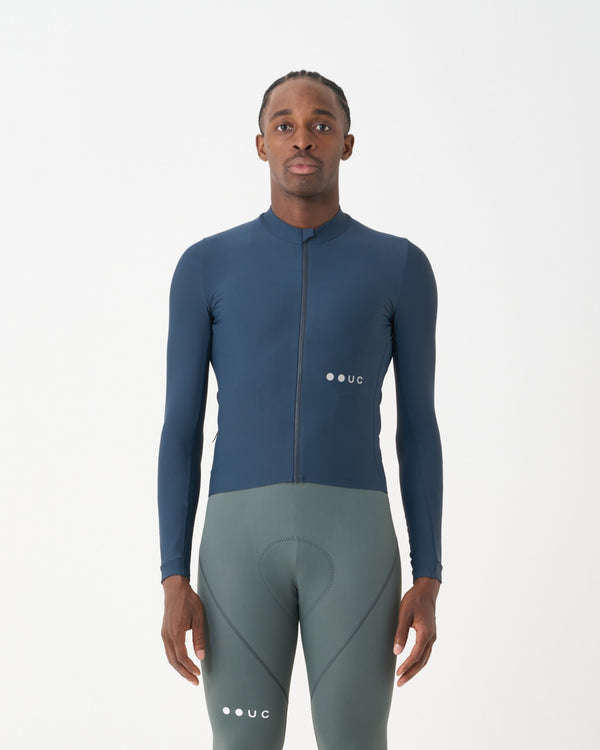 Model wearing the Men's Mono Long Sleeve Jersey in Eclipse Navy, front view, paired with sage green cycling bib tights.