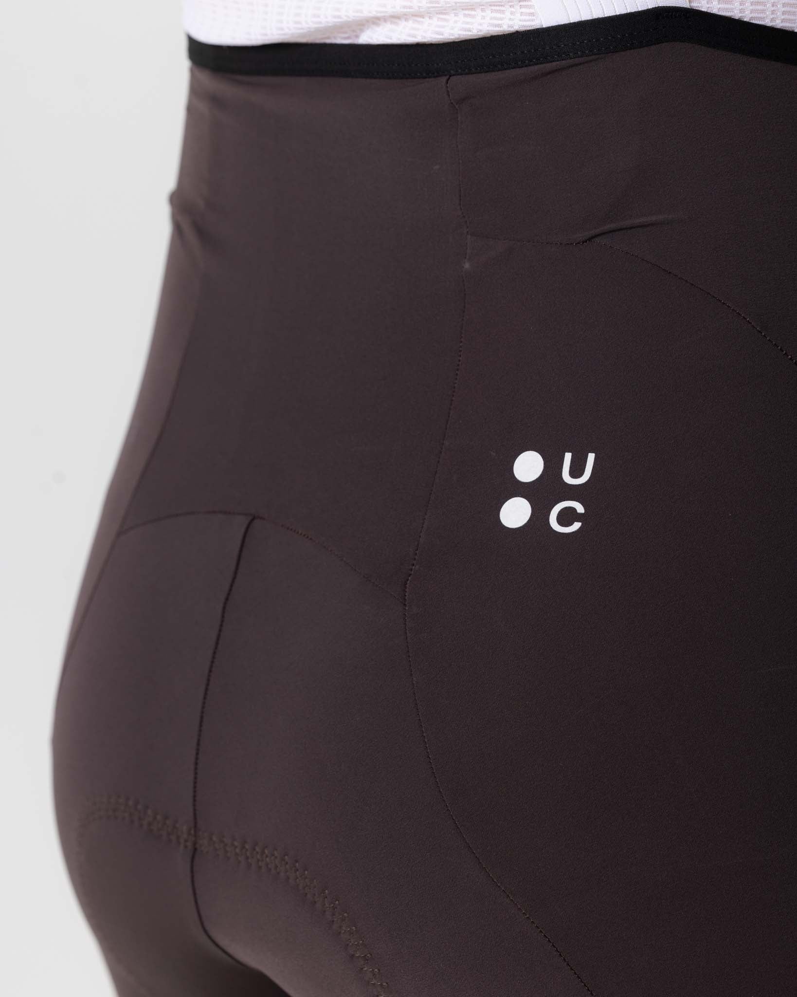 Rear detail: slim drop-in mesh pocket and tonal UC roundel on the back of the Heavy Bark Brown Chroma Bib Shorts.