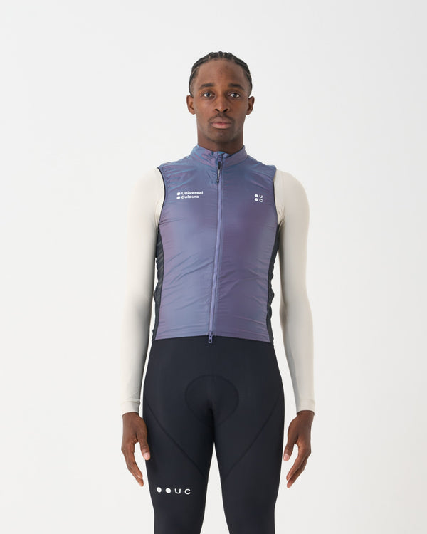 Male model in the Unisex Spectrum Gilet 2.0 in Iridescent Violet over a cream base layer and black UC bib tights.