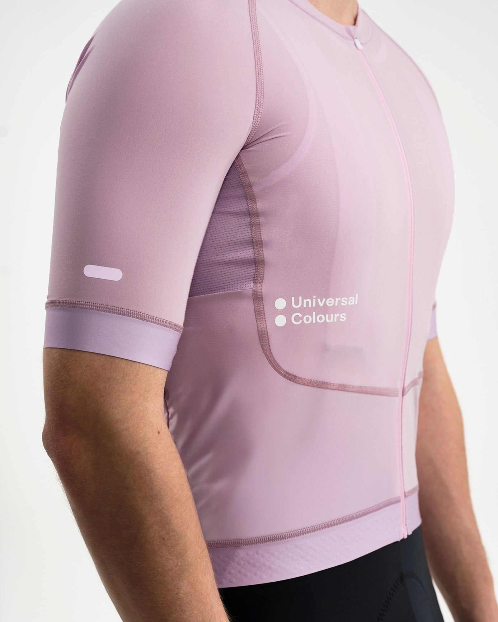 Close-up of the Washed Lilac Chroma Jersey: reflective sleeve bar, mesh side panel and Universal Colours chest wordmark.