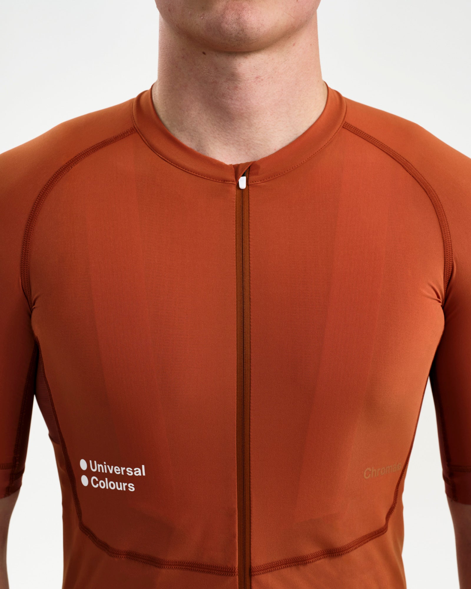 Front torso close-up: two-way zip and Universal Colours chest wordmark on the Cyprus Copper Men's Chroma Short Sleeve Jersey.