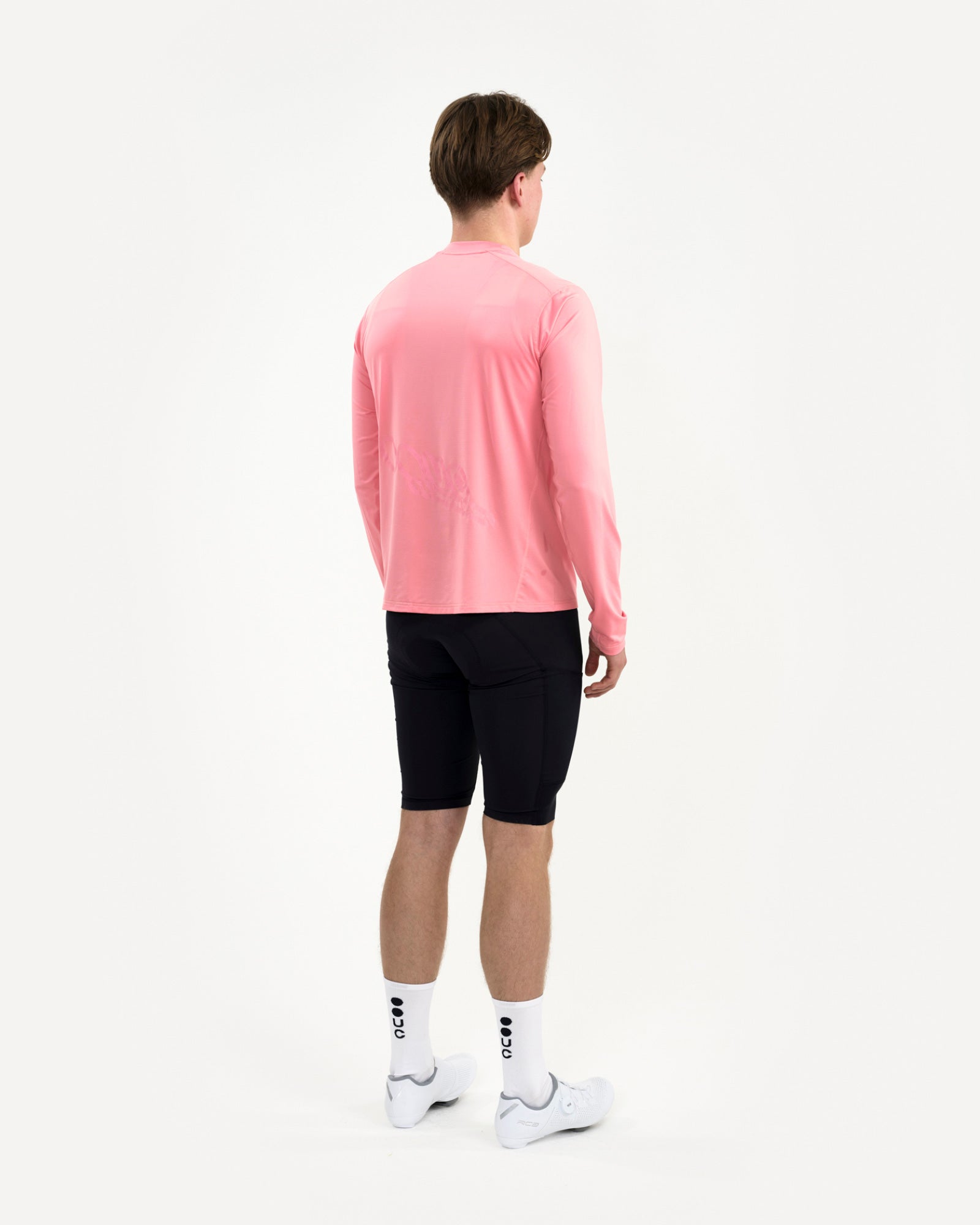 Men's back-three-quarter view of the Long Sleeve Tech Tee in Washed Pink with clean dropped hem and tonal back graphic.