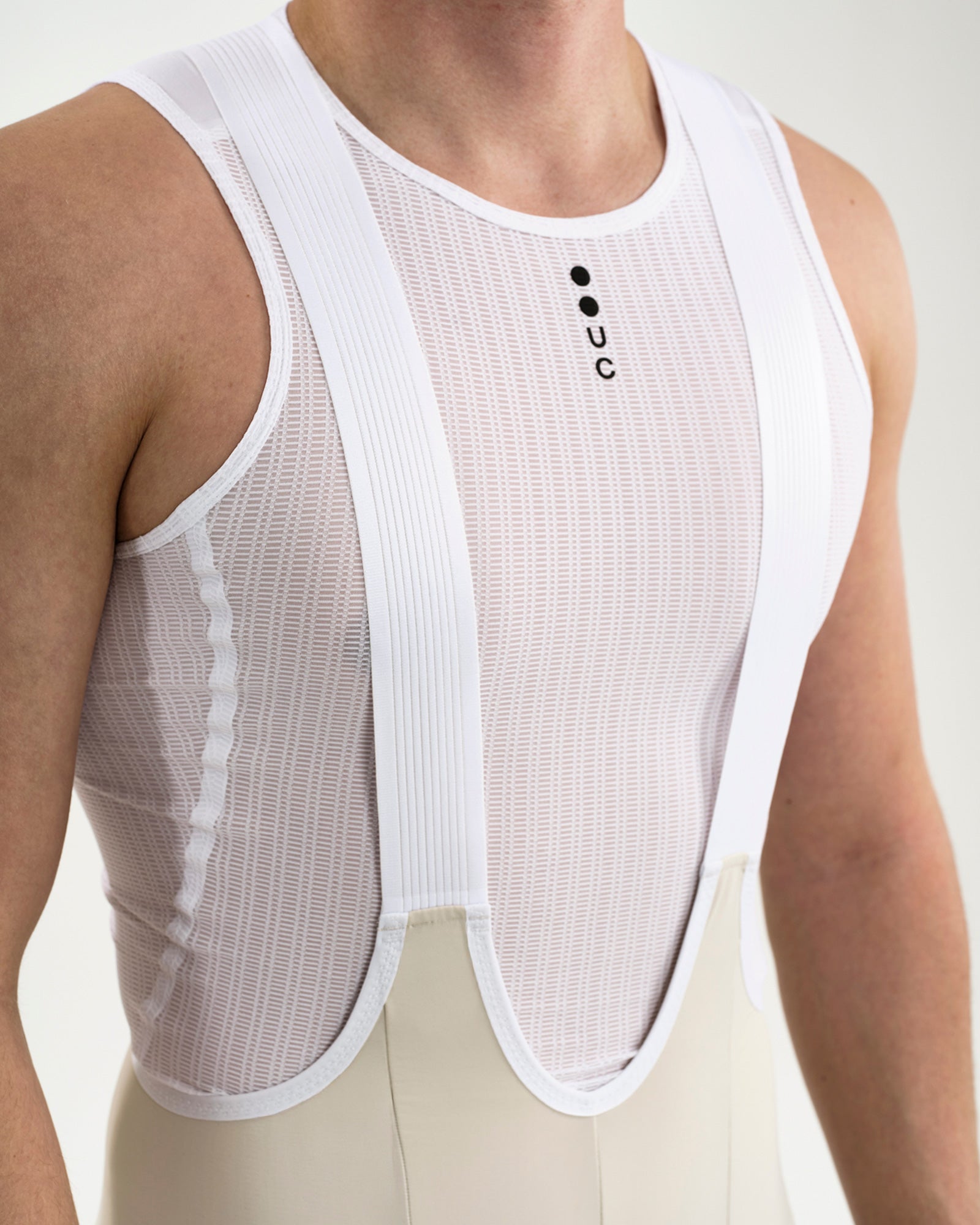 Close-up of the wide ribbed white bib straps and sheer mesh panel of the Men's Mono Bib Shorts 2.0 in Off White.
