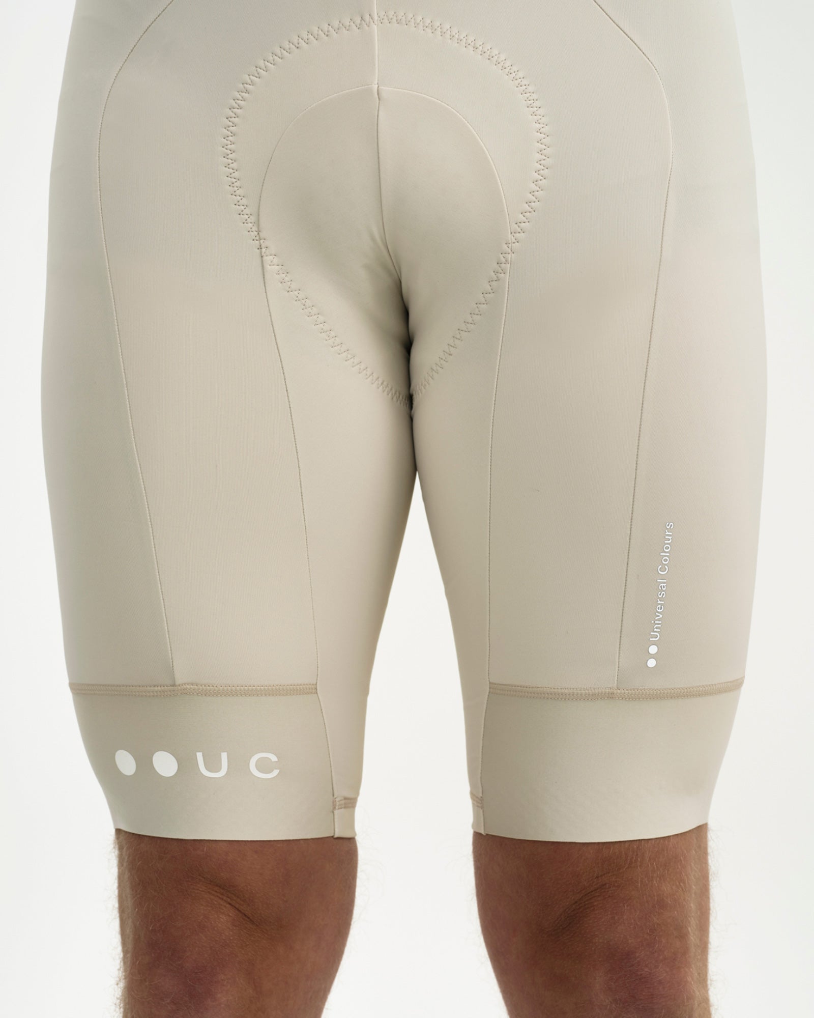 Rear hem detail: reflective white Universal Colours wordmark and UC roundel on the Off White Mono Bib Shorts 2.0.