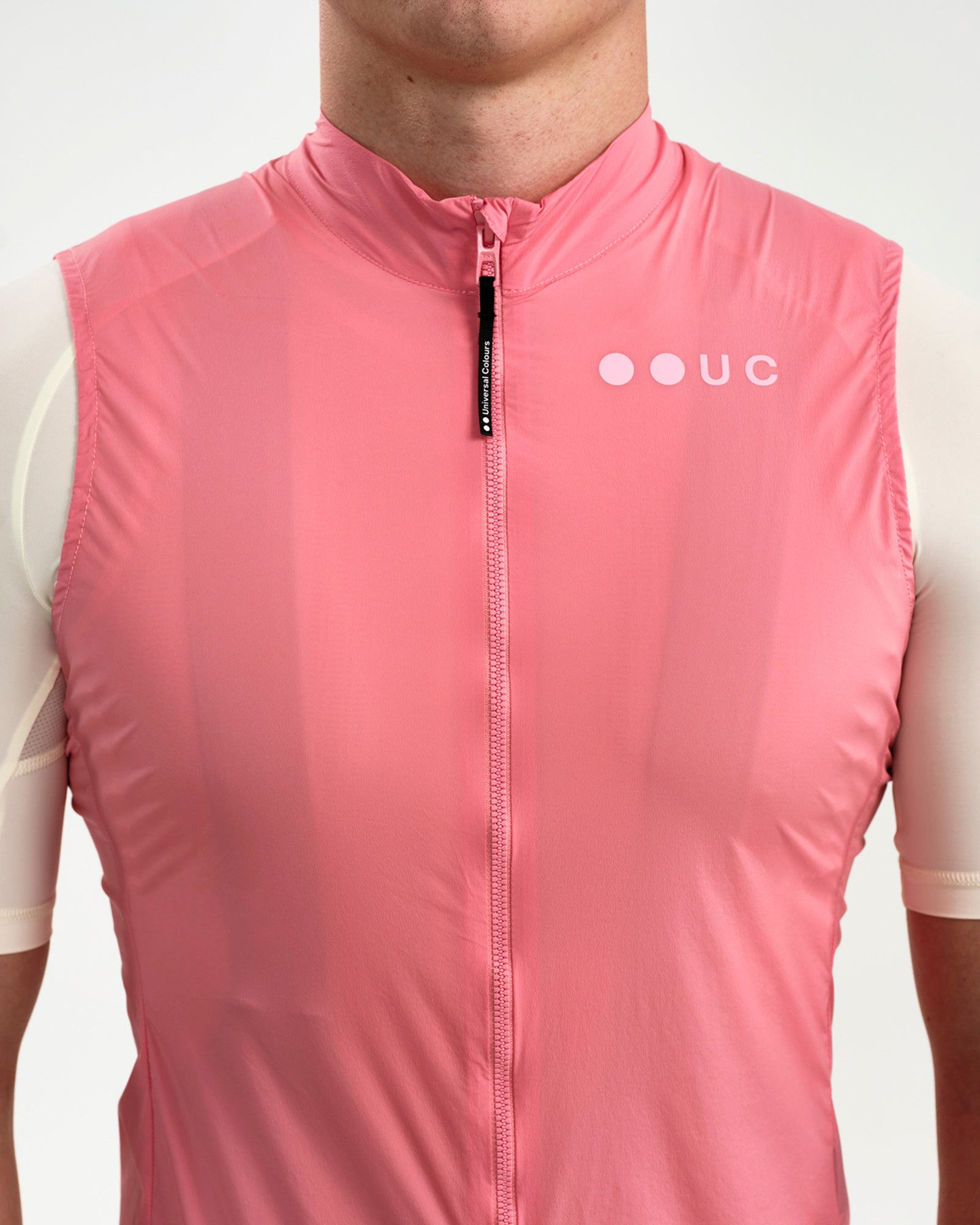Chest close-up of the Men's Mono Gilet 2.0 in Washed Pink: full-length zip, zip garage and tonal UC logo.