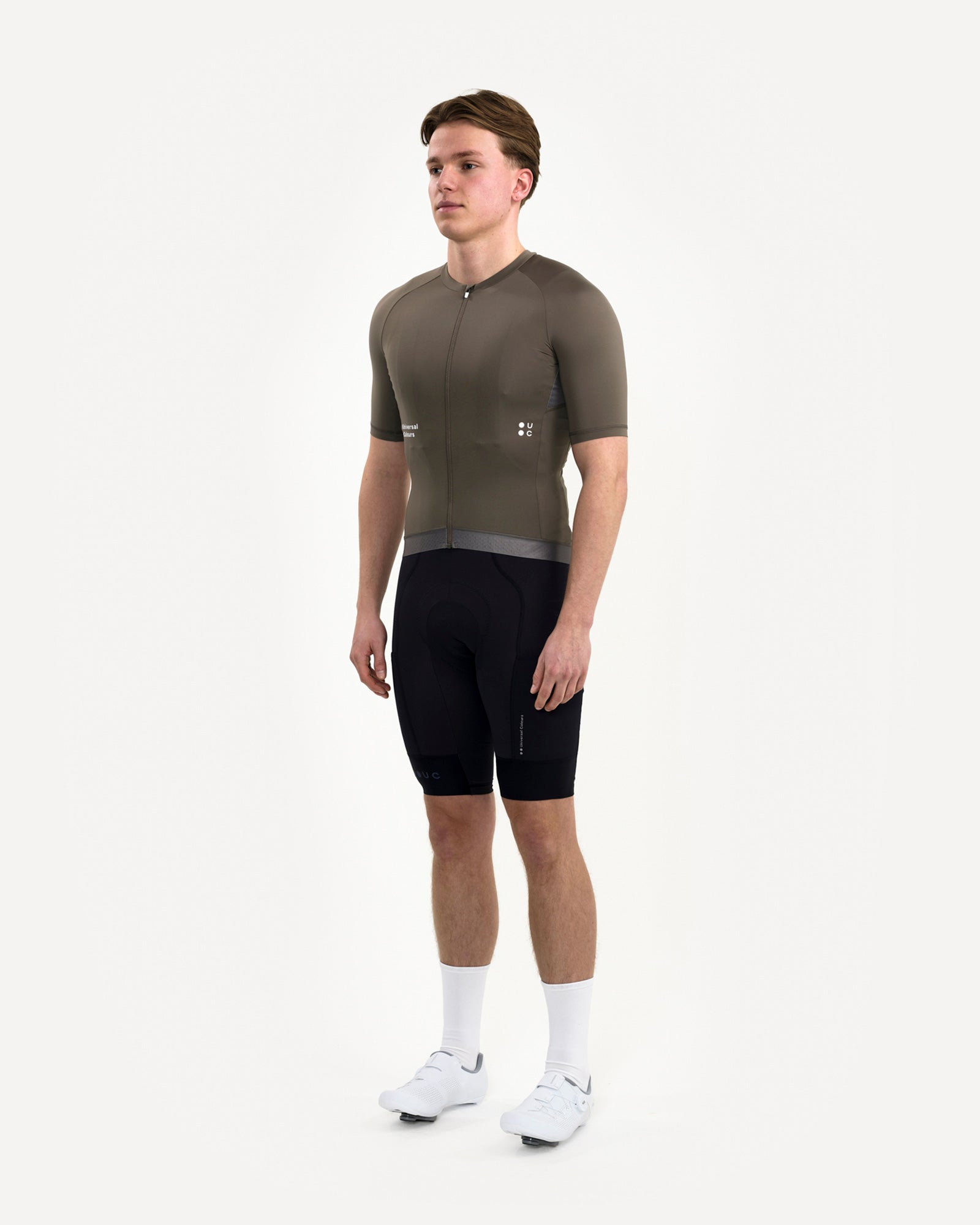 Three-quarter front view: Men's Mono Short Sleeve Jersey in Soft Grey on model, paired with UC black cycling bib shorts.