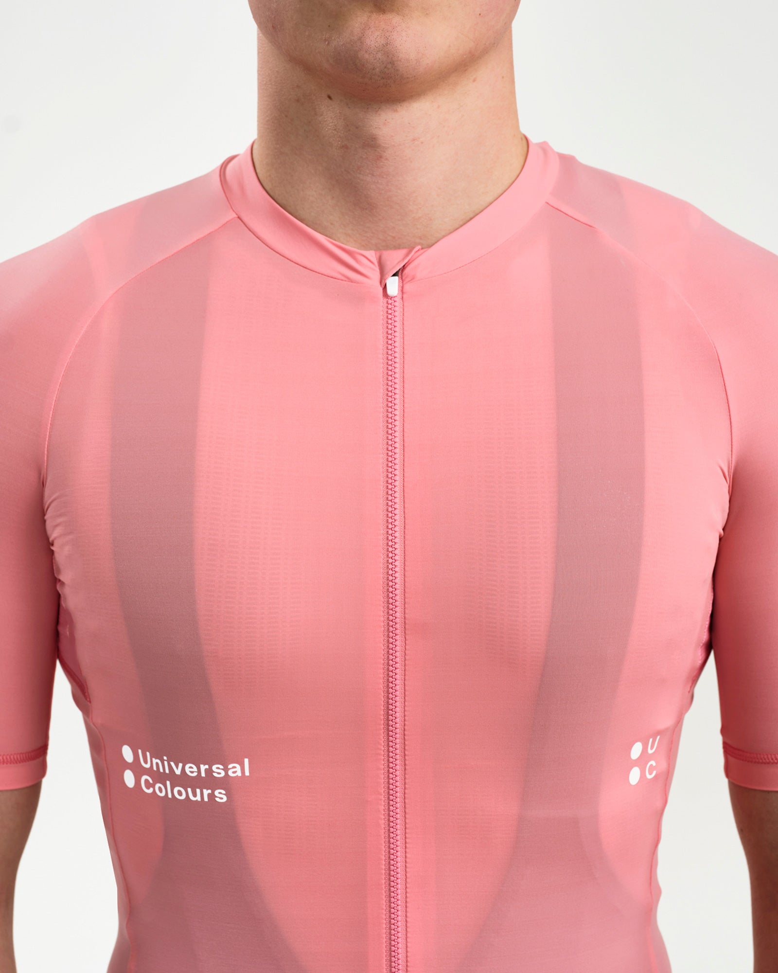 Front torso close-up of the Men's Mono Short Sleeve Jersey in Pink: centre zip, tonal stripe fabric and white UC chest logos.